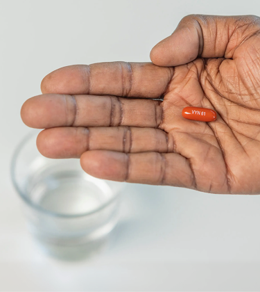 A hand with palm facing up holding a VYNDAMAX (tafamidis) pill