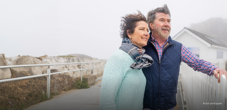 Actor portrayal of an older couple outdoors with wind in their hair