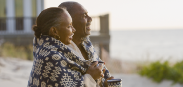 Patient and caregiver enjoying seaside sunset