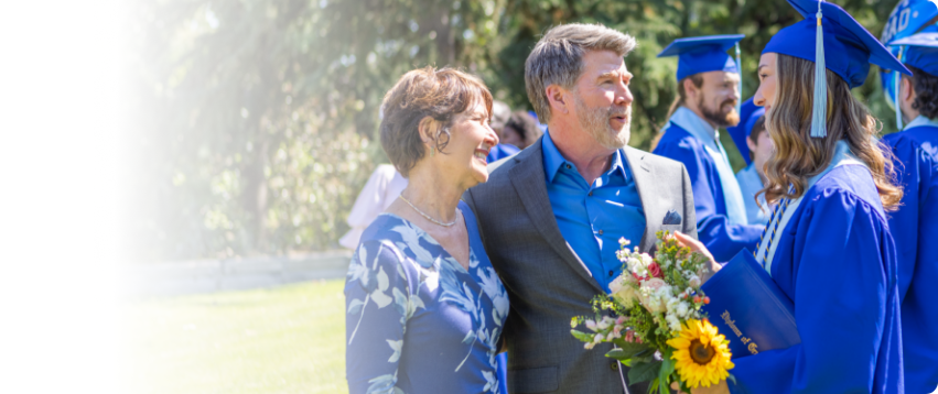 Actor portrayal of a family engaging in conversation at their daughter's graduation