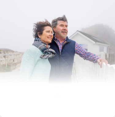 Actor portrayal of an older couple outdoors with wind in their hair